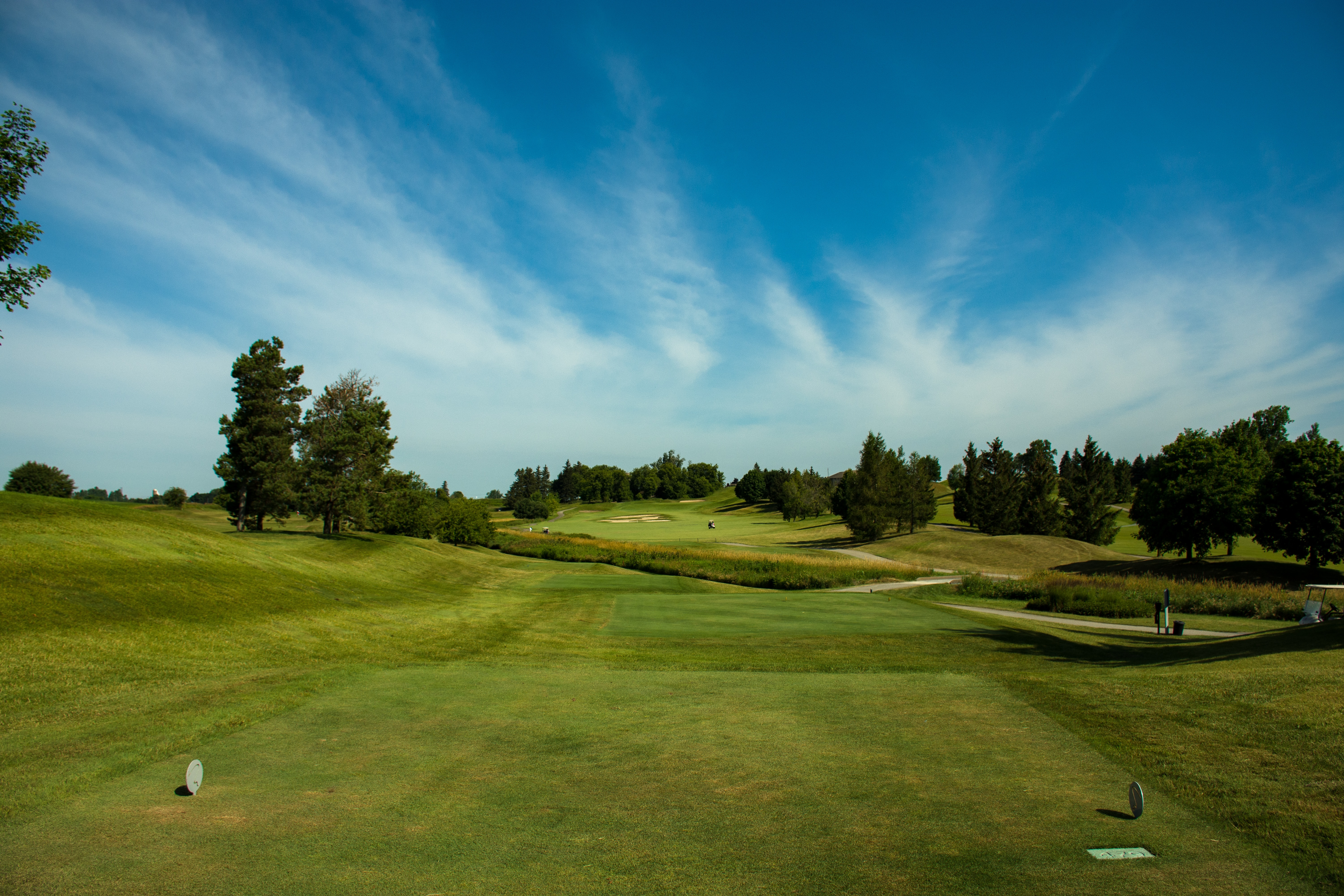 golf course stretching out under clear blue sky